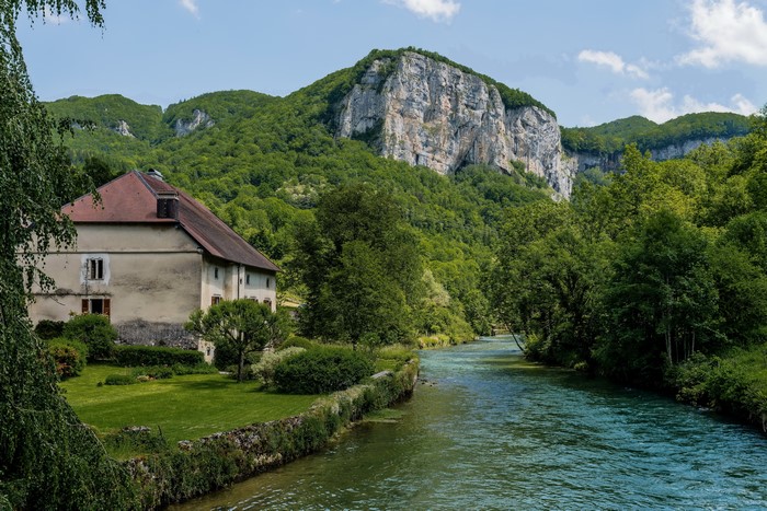House by the river with mountains in Mouthier Haute Pierre, France