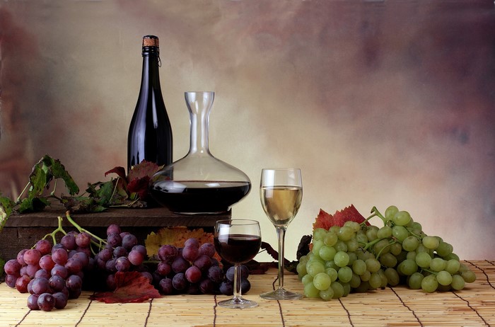 Wine bottle, decanter, and grapes with stemware