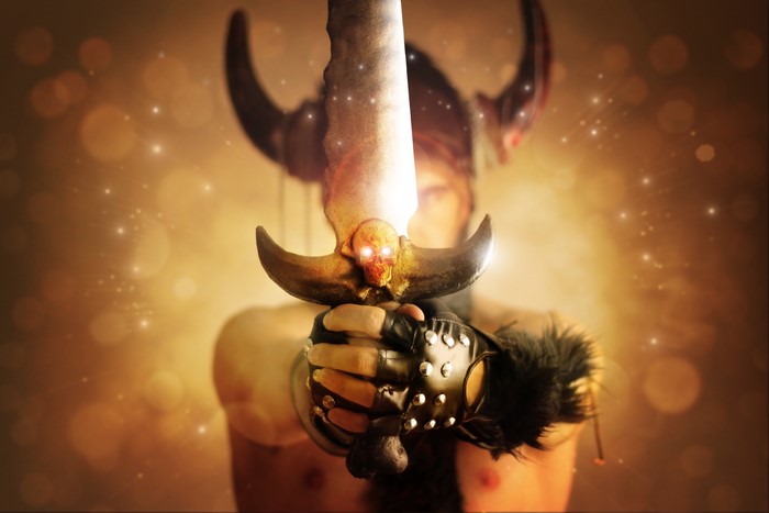 Man with horns and sword with skull