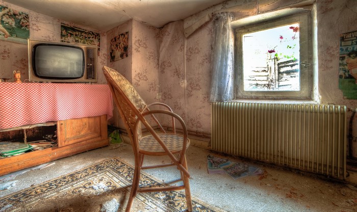 Abandoned room with vintage TV and chair