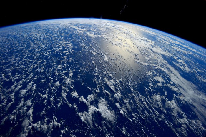 Earth's surface from space with clouds and ocean