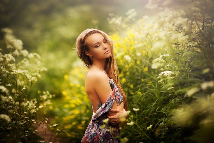 Blonde girl in a floral dress in a field