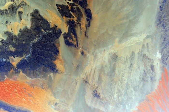 Satellite view of desert landscape with sand dunes and mountains