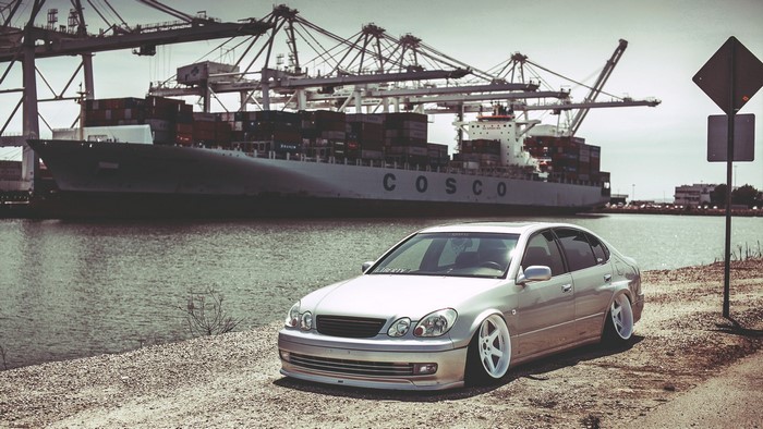 Lexus GS300 parked by a COSCO container ship at a port