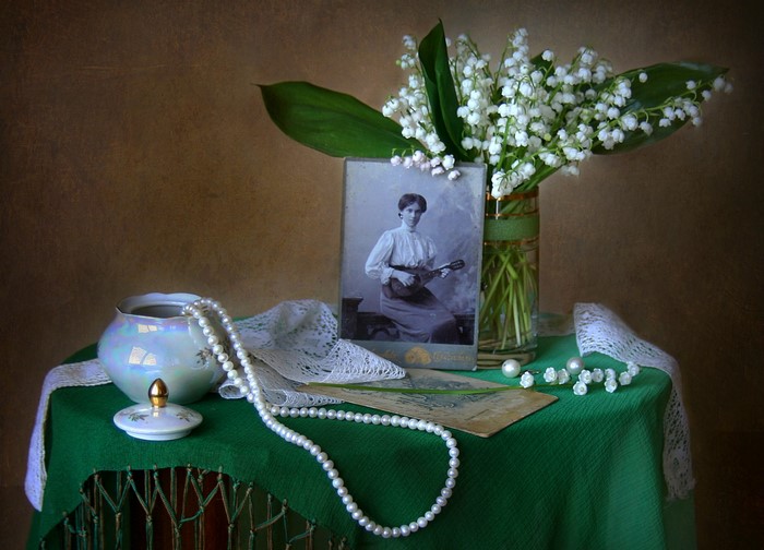 Still-life with lilies of the valley and vintage photo
