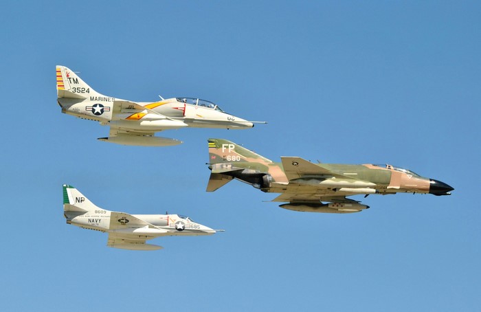 Three vintage fighter jets flying in formation