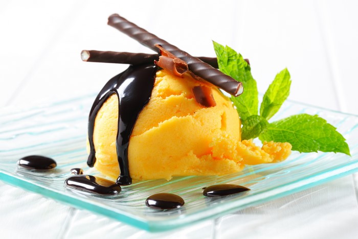 Orange ice cream with chocolate sauce and mint