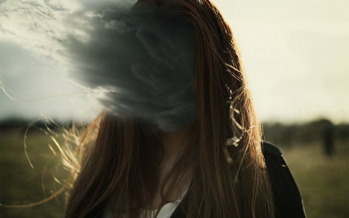 Woman with dark clouds obscuring her face
