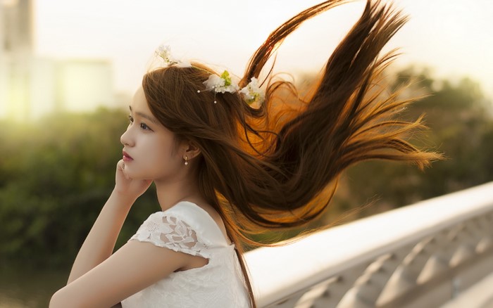 Asian woman with brown hair and flowers in hair
