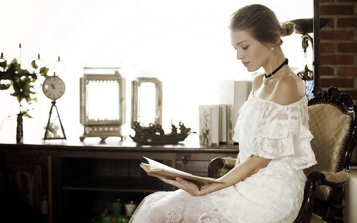 Woman in white dress reading a book