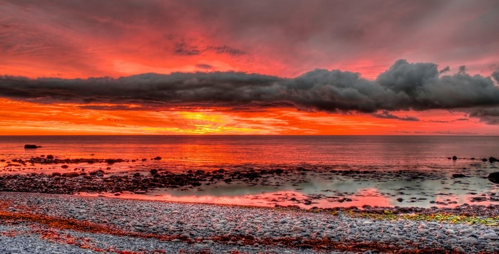 Dramatic sunset over a rocky coastline and the sea
