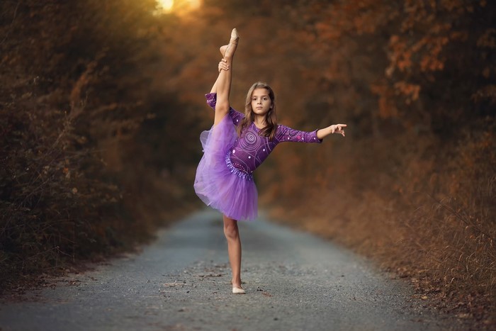 Young girl in a purple tutu performing ballet