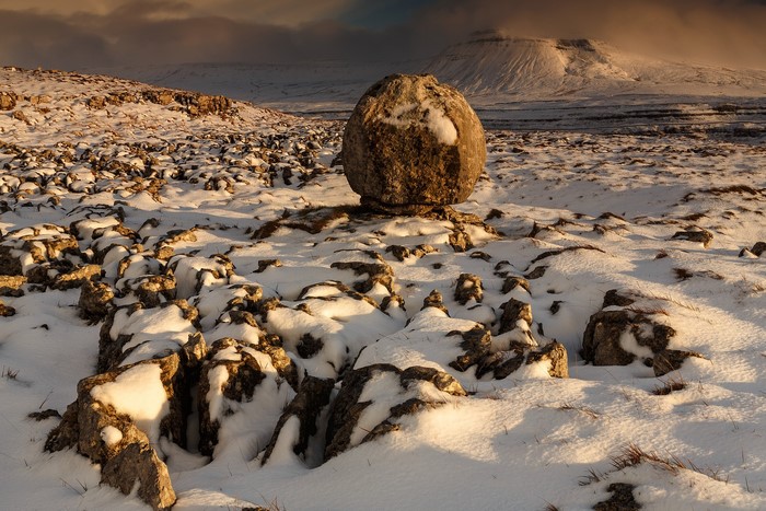 Balancing stone on a snowy landscape in Yorkshire Dales