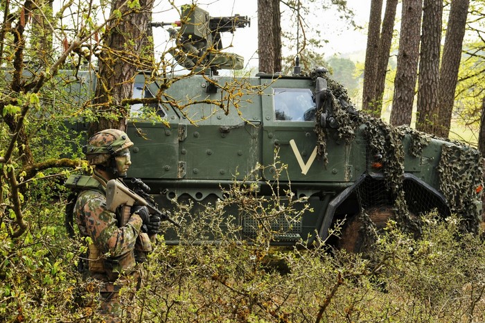 Soldier with military vehicle in forest