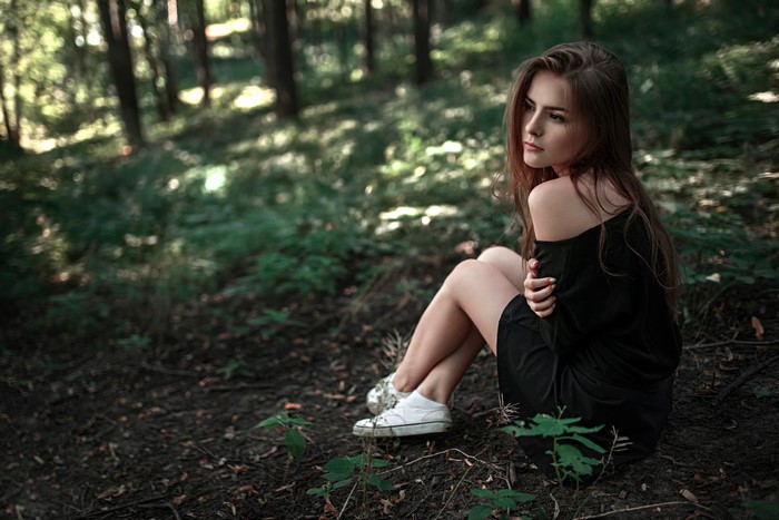 Brown haired girl sitting in a forest