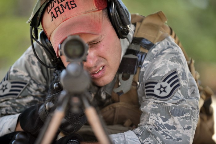 Soldier aiming a sniper rifle with a red cap