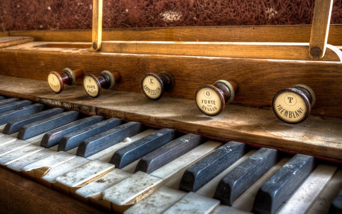 Close-up of an old pipe organ keyboard and stops