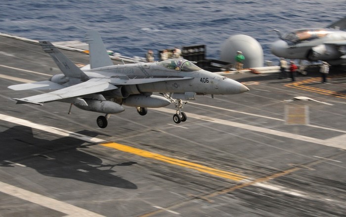 Fighter jet landing on aircraft carrier