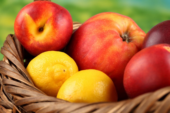 Fruit basket with apples, peaches, and lemons
