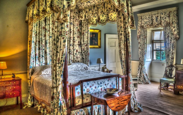 Four-poster bed with floral curtains in a bedroom