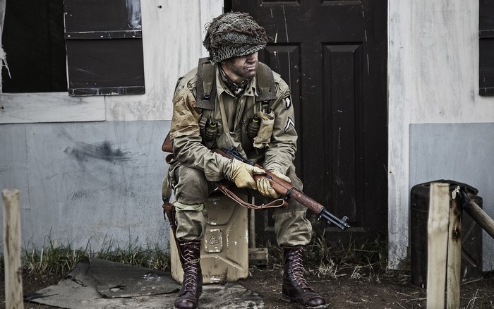 Soldier in uniform sitting with rifle