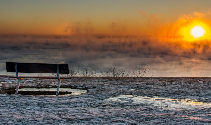 Bench overlooking foggy sunrise in winter