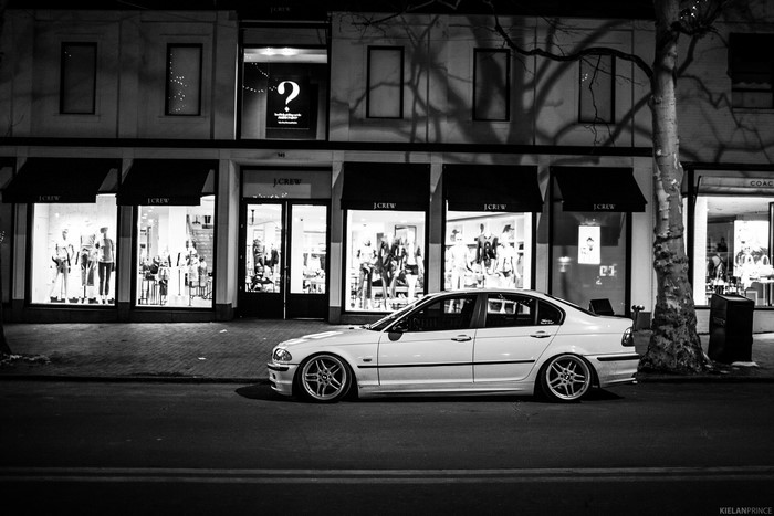 White BMW 323i parked on a street at night