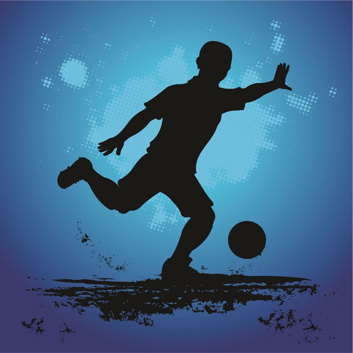Silhouette of a soccer player kicking a ball