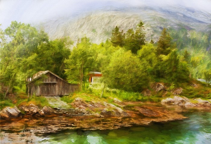 Wooden boathouse by a lake with mountains in the background