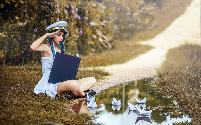Girl in sailor hat reading a book by a puddle