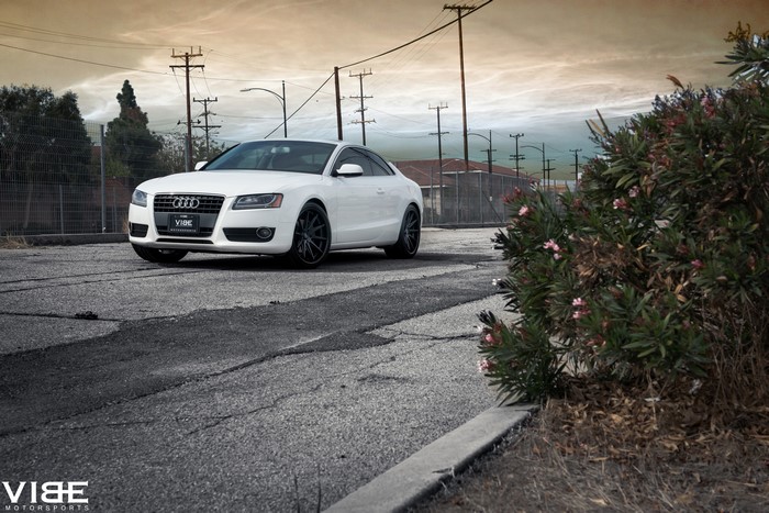 White Audi A5 on asphalt road with power lines