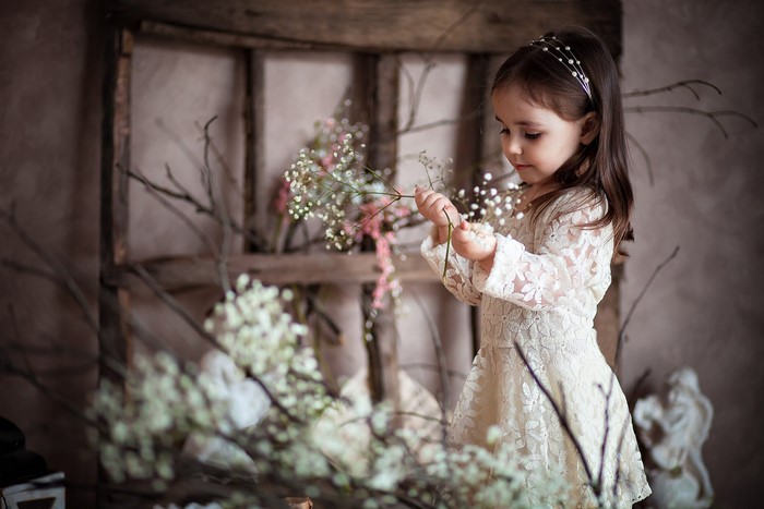 Young girl in a lace dress holding flowers