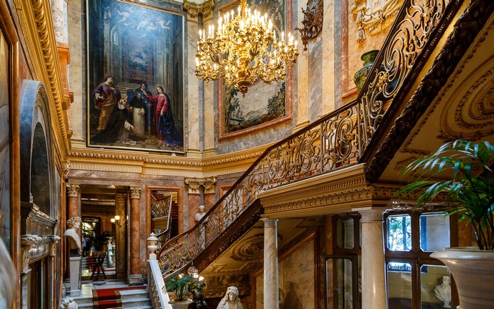 Palace interior with grand staircase and painting