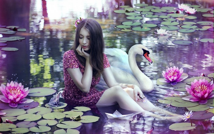 Girl and swan in a pond with water lilies
