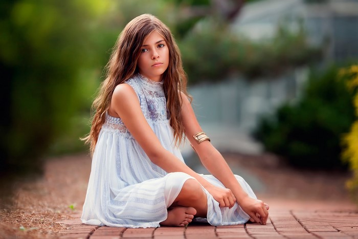 Girl with wavy brown hair in a light blue dress