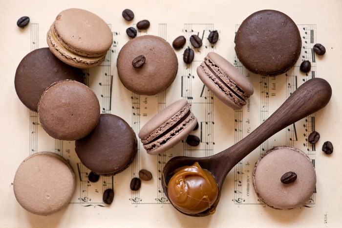 Chocolate and coffee macarons on sheet music with caramel