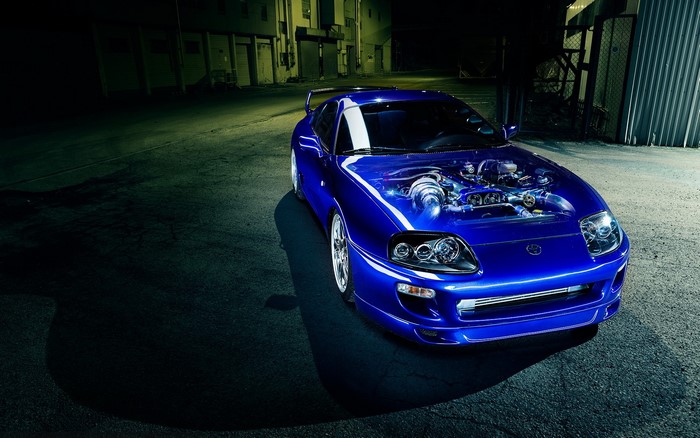 Blue Toyota Supra with exposed engine at night
