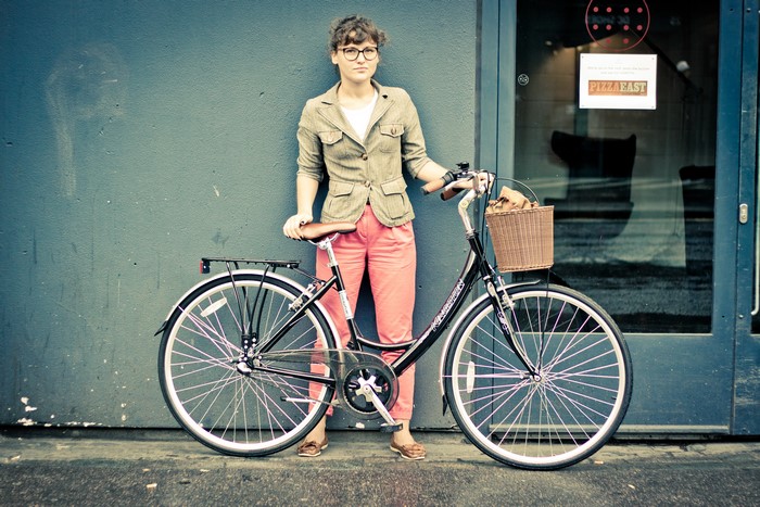 Woman with bicycle in front of Pizza East door