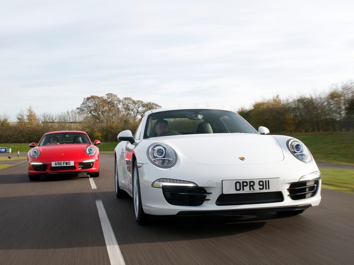 Two Porsche 911 cars on a road