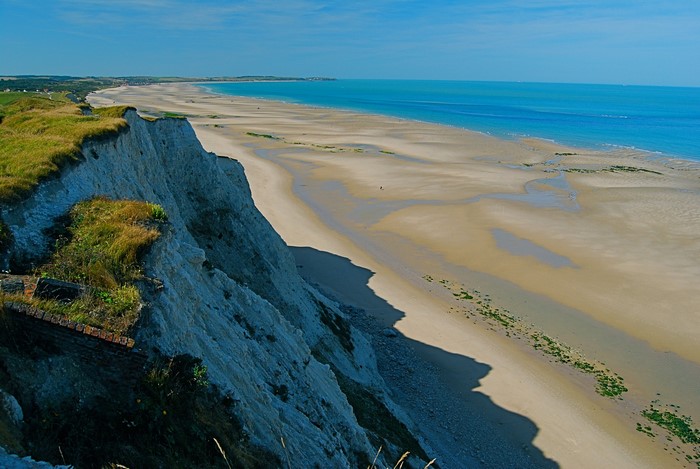 White cliffs overlooking a wide sandy beach and the sea