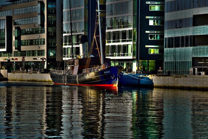 Ship named BORE docked by modern buildings