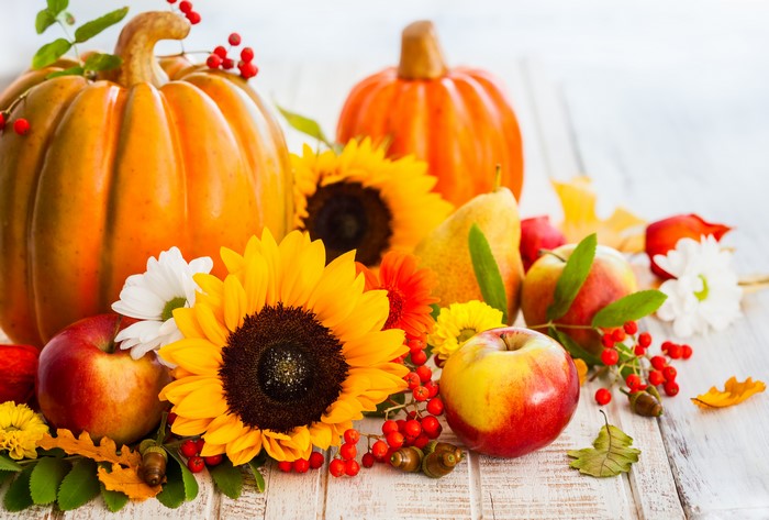 Autumn harvest arrangement with pumpkins, apples, and sunflowers