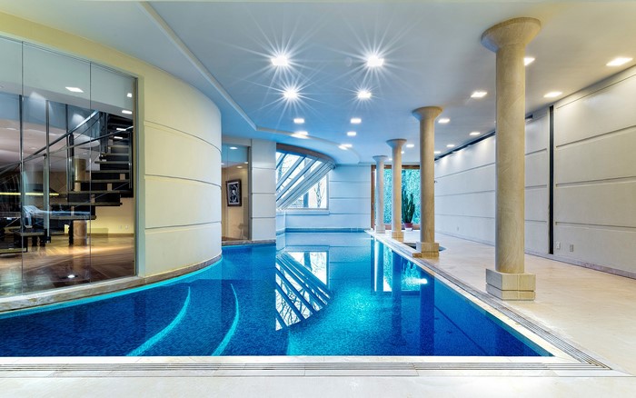 Indoor swimming pool with modern architecture and spiral staircase