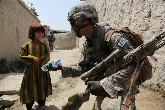 Soldier gives water to a girl in Afghanistan