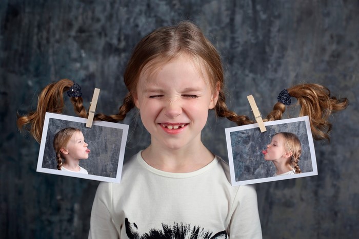 Girl with pigtails and photos clipped to them
