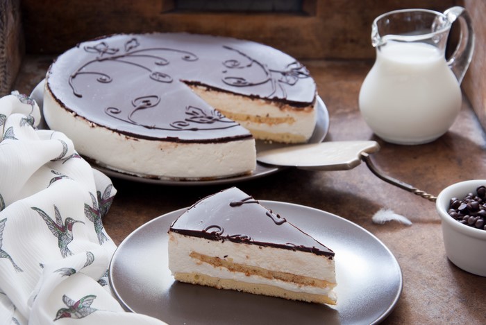 Chocolate glazed cake with a slice on a plate