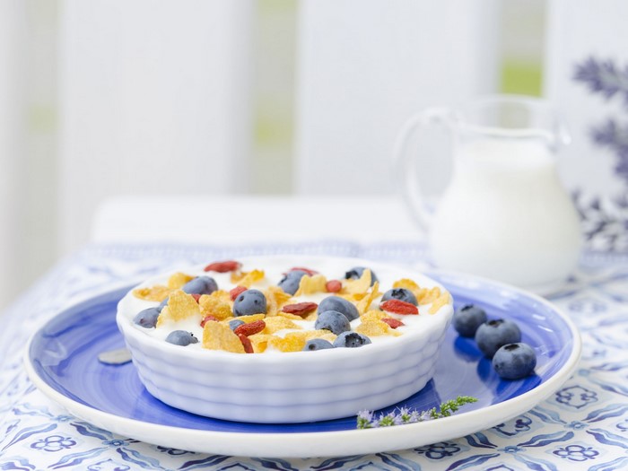 Bowl of cereal with blueberries and milk pitcher
