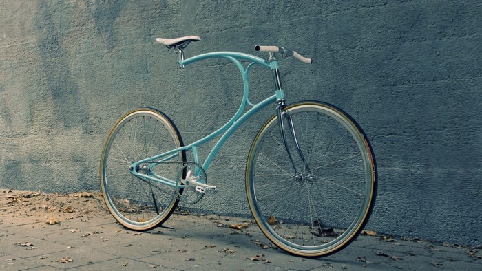 Light blue custom bicycle leaning against a wall