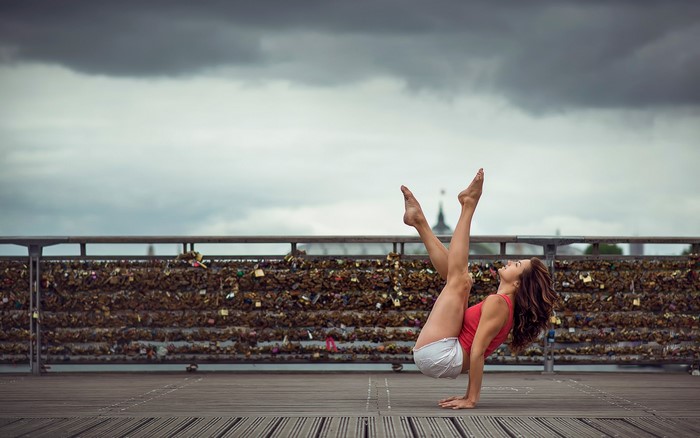 Woman performing a yoga pose on a bridge
