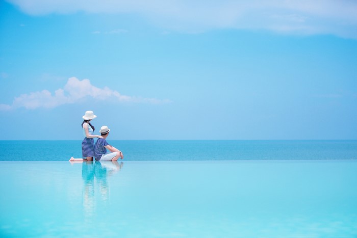 Couple by the infinity pool overlooking the sea